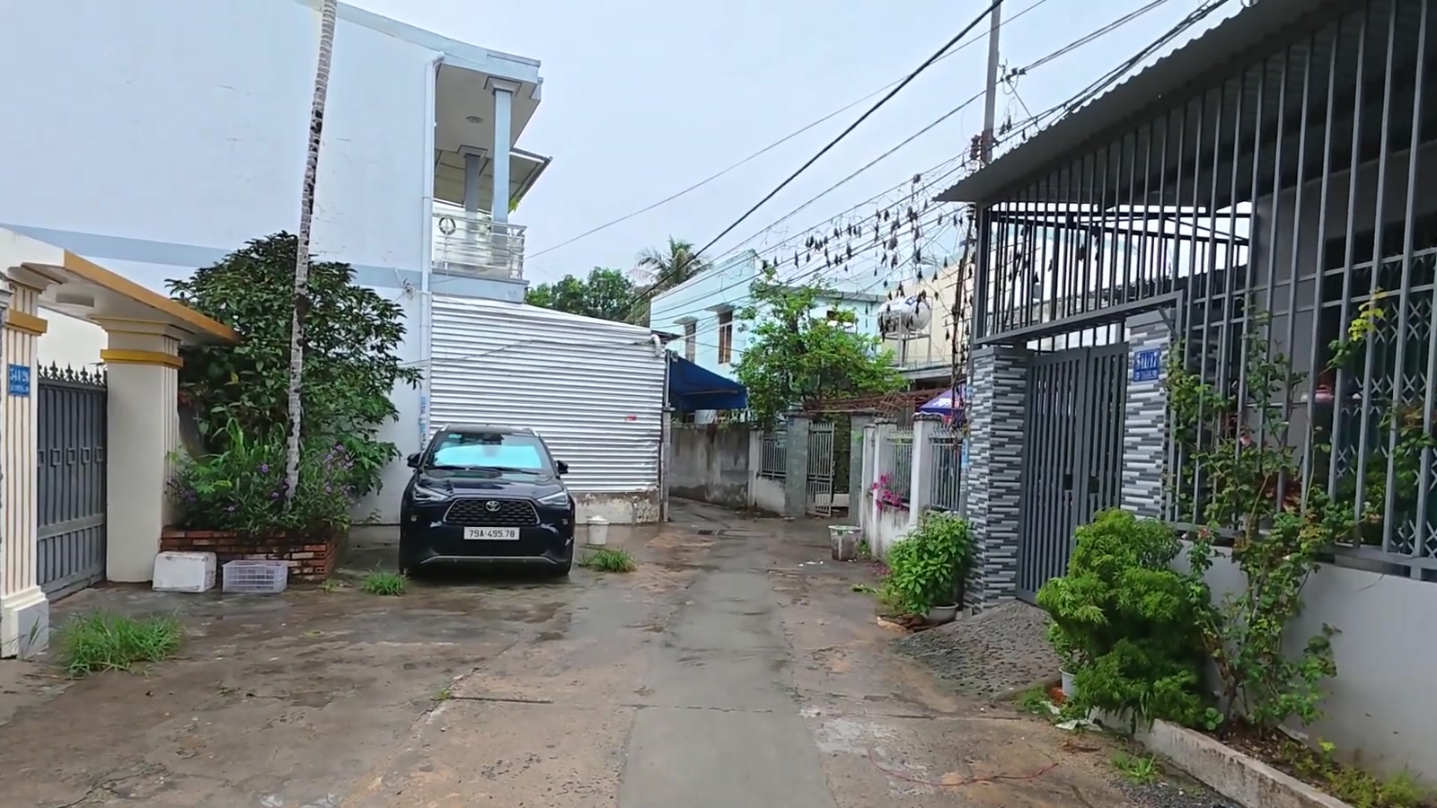 Đường bê tông trong khu dân cư, ô tô đậu trước nhà hàng xóm ở khu Vĩnh Châu, Tây Nha Trang