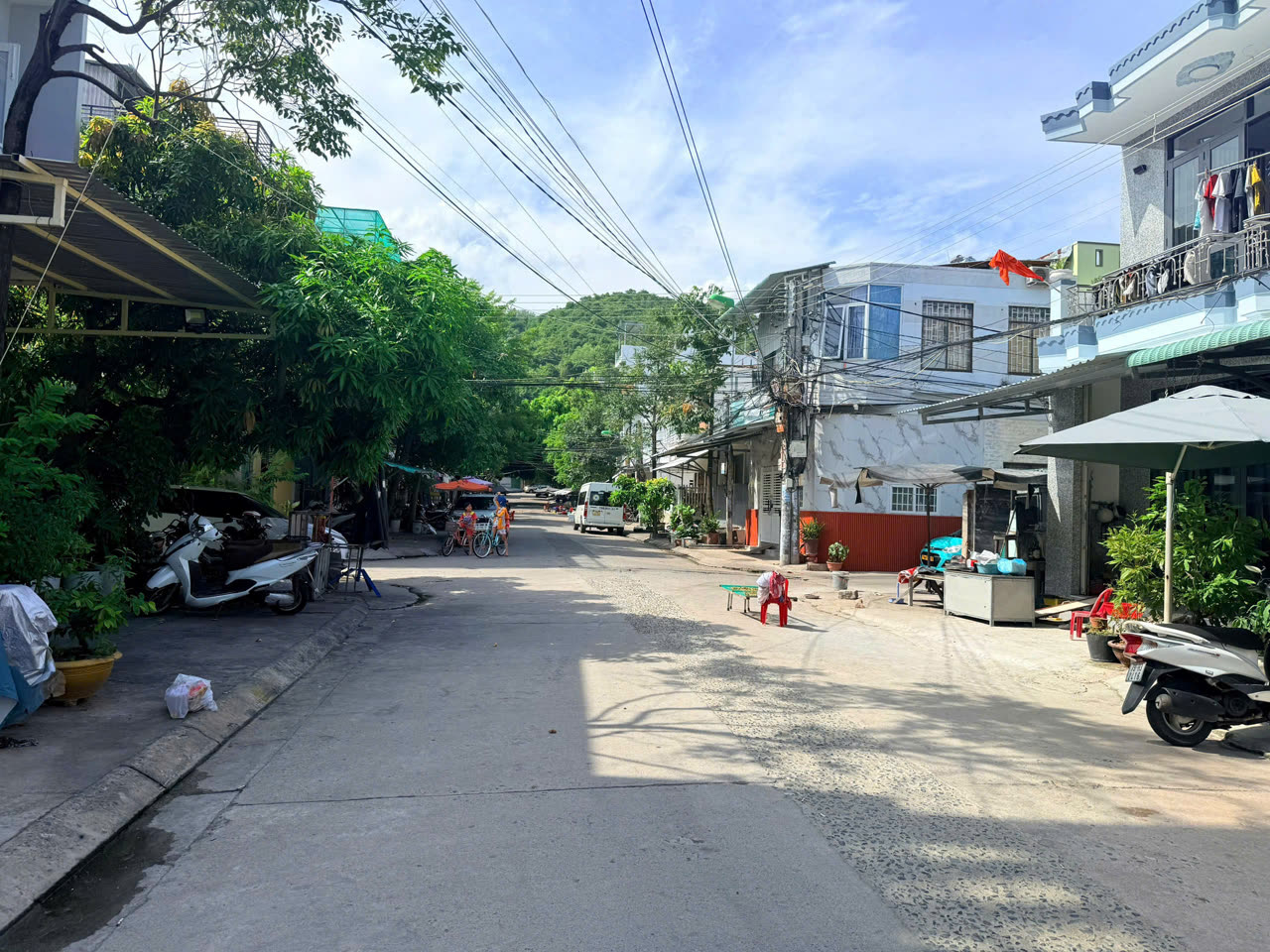 Đường Diệp Minh Tuyền Nha Trang rộng hơn 10m trước căn nhà, hai bên có vỉa hè, xa xa là núi