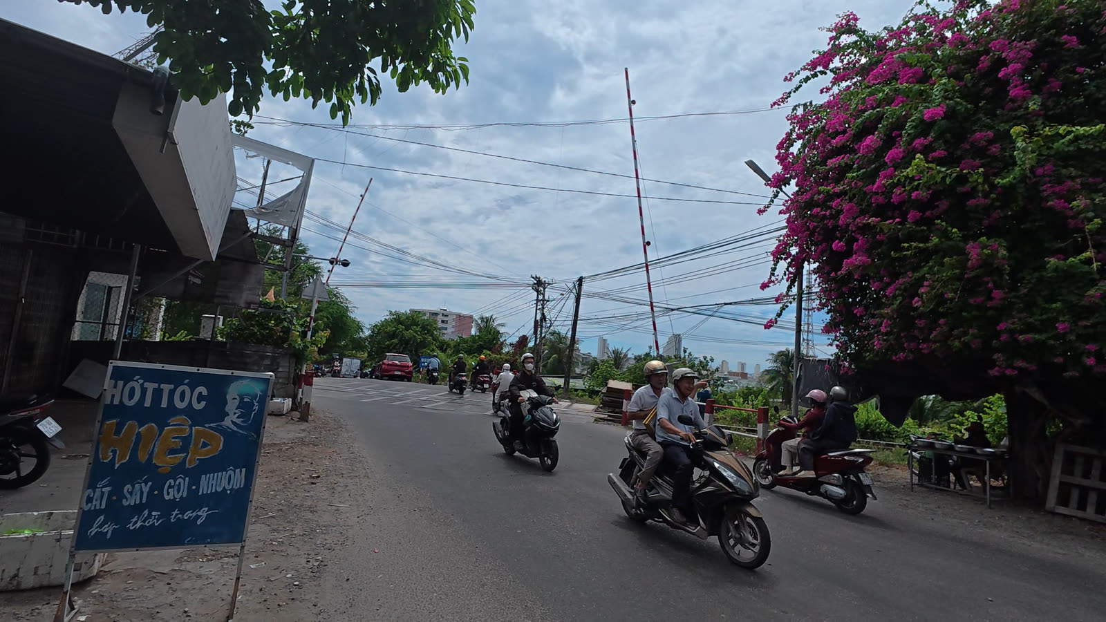 Gác chắn đường ngang dân sinh trên đường Nguyễn Xiển nơi đường sắt Bắc Nam cắt ngang, xe máy nối đuôi qua đoạn thắt cổ chai