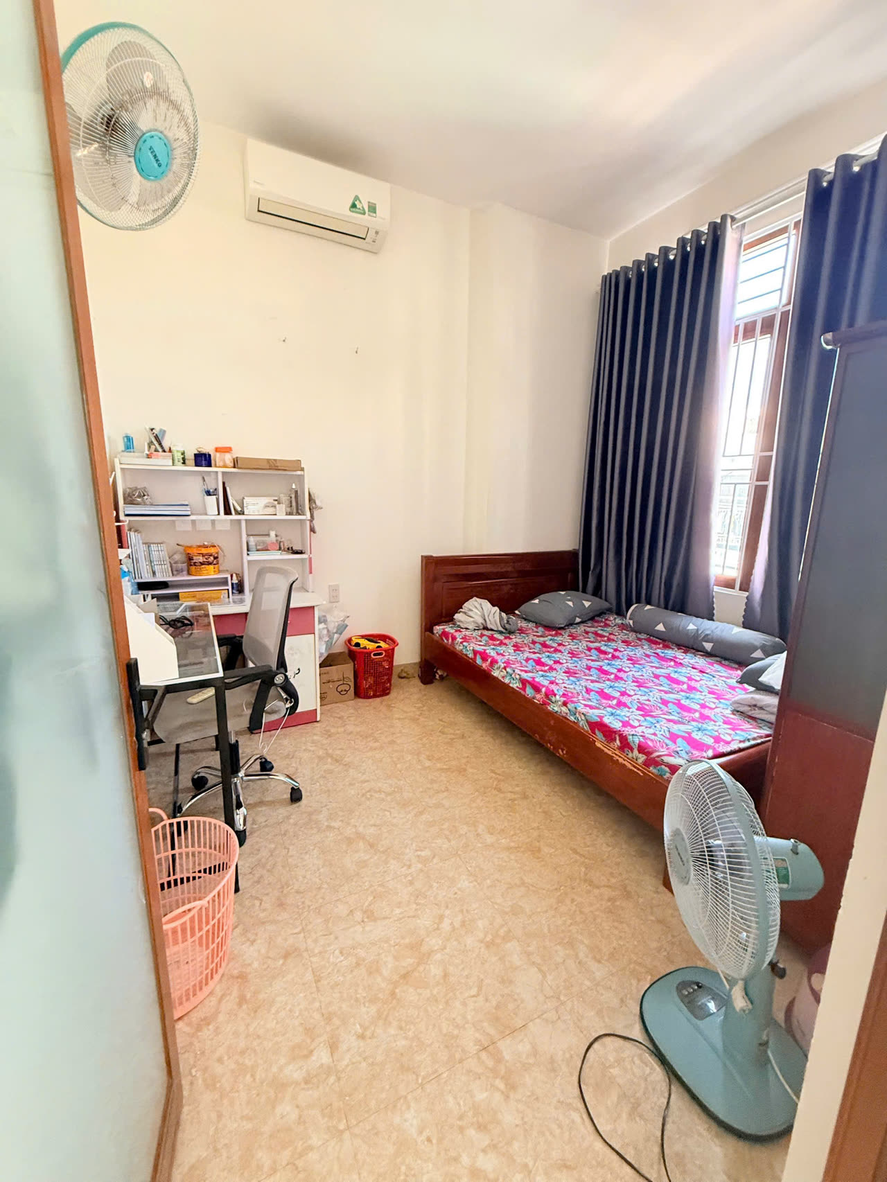 Phòng ngủ nhà Diệp Minh Tuyền Nha Trang kê bàn học, kệ sách và máy lạnh