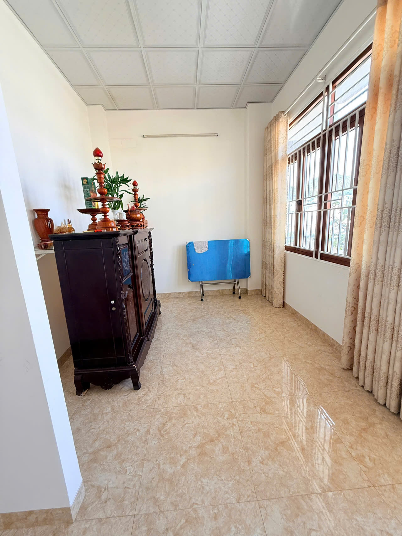 Phòng thờ nhà Diệp Minh Tuyền Nha Trang với tủ thờ gỗ sẫm và cửa sổ lớn đón sáng