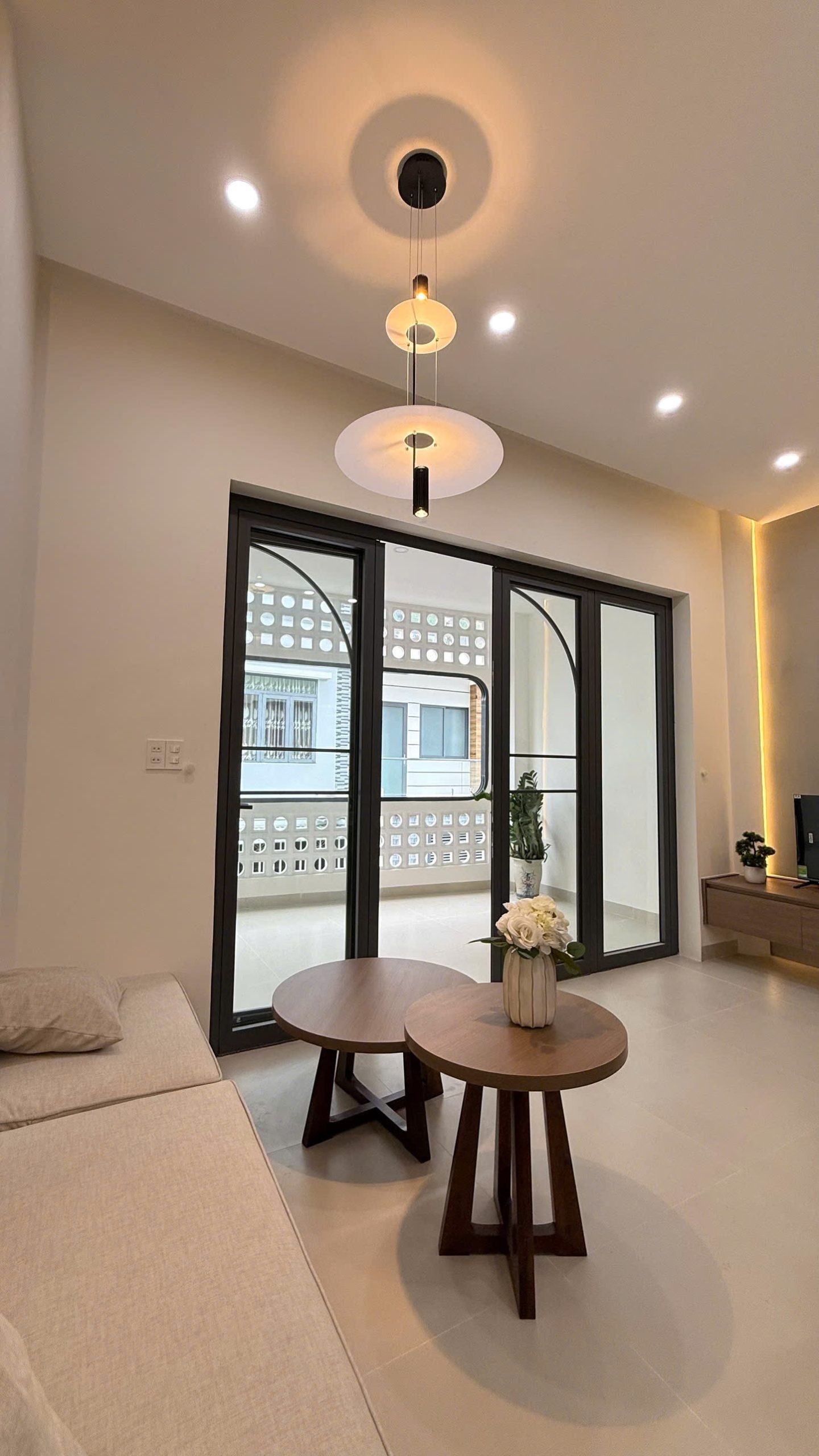 Ban công rộng của căn hộ tầng 2 nhìn từ phòng khách qua cửa kính khung đen